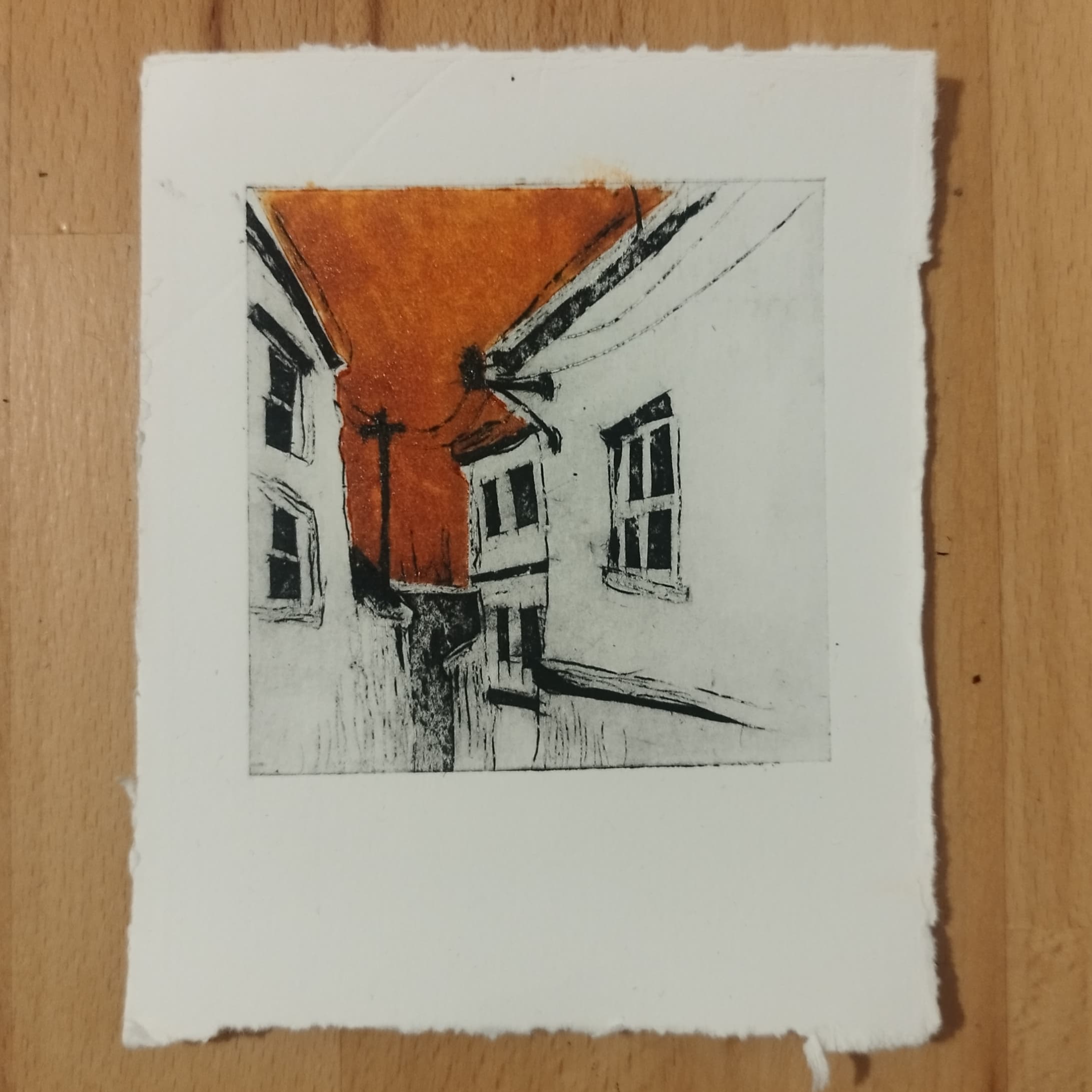 Gravure rehaussée de couleur orangée représentant une ruelle à colombages et ses toits pentus